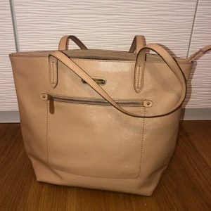 Victoria’s Secret väska  - Superfin glansig väska från VS. Materialet är som plats/läder och är väldigt hållbart!! Den är mycket rymlig inuti och har ett mindre fack i med dragkedja samt eller på utsidan. Det finns även två vanliga fack utan dragkedja. Köparen står för frakt