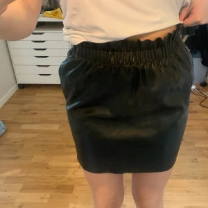 Kjol från HM  - Svart skinnkjol från hm med resor i midjan
