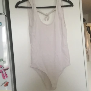 Vit body stl s - Vit body med Knut framtill. Öppnar nere i grenen. Öppen rygg.