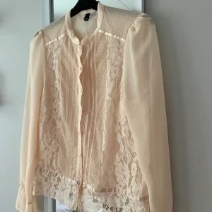 Spetsblus från HM - Aprikosrosa blus i spets från HM med fina detaljer 🧡 den är använd vid ett tillfälle och i väldigt fint skick! Frakt tillkommer och vid flera köpare blir det budgivning som avslutas 24 timmar efter första budet 🧡
