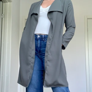 Grön Trenchcoat - Fin tunn trenchcoat💞 säljer då den inte kommer till användning. Nyskick och bara använd ca 3ggr! Skriv för fler bilder.