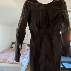 Skinnklänning - Oanvänd tight svart skinnklänning med djup rygg! Sitter väldigt snyggt och framhäver formerna! Säljer pga beställde två likadana men älskar denhär klänningen! Köparen står för frakten