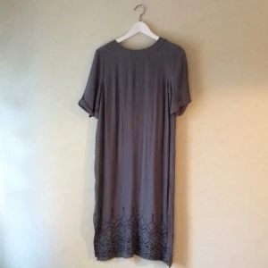  - Helt oanvänd klänning från indiska. Fint tyg och broderad kant nertill. Frakt tillkommer. 