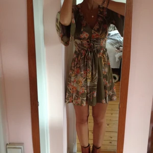  - Fin mönstrad klänning i grönt o orange. Inköpt på solo för flera är sedan. Använt en gång. Ganska kort med snörning under bysten + vida ärmar. SÅ snyggt! A la 70's.