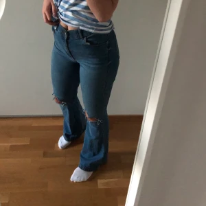 Blåa bootcut jeans - Blåa bootcut jeans från Dr Denim, egengjorda och skitsnygga hål på knäna. Dom sitter även som en smäck i rumpan! Dom är även perfekta i längden på mig som är 170