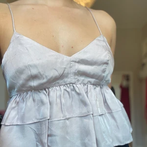 Söt festtopp! - Superfin volangtopp i en pärl/lila/rosa färg med smala band, funkar både till fest och vardags!