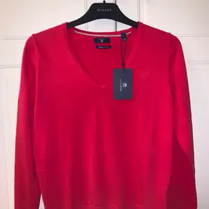 En helt ny, oanvänd Gant tröja med lappen fortfarnade på!! Färgen är inte rättvis på bilden då tröjan inte är helt röd utan lutar åt röd/rosa. 
