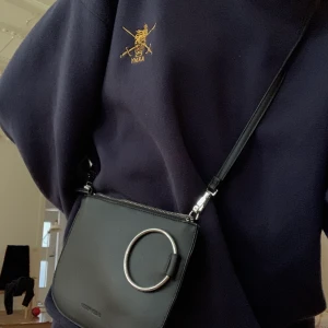 svart väska med silverdetalj - cool väska från carin wester med en silverring på!! användas väääldigt lite, så den är i väldigt bra skick:) 