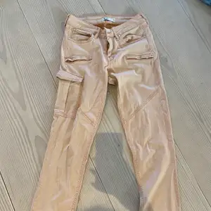 Cargo aktiva byxor från Gina tricot i en nude rosa färg, fickor på sidorna, tajta men stretchigt material, använt 1 gång för en fest