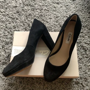 Klackar (ca. 7,5 cm) från Clarks  - Väldigt fina och knappt använda sammetsklackar från Clarks, nypris låg på just under 1000 kr. De få gånger de använts har det varit inomhus. Säljes endast pga för liten storlek för mig. Vid leverans står köparen för portot!