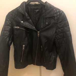 Svart skinnjacka  - Svart skinnjacka från Lindex i storlek 36.