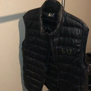EA7 Väst - Hej säljer min EA7 väst för att jag vill ha en ny. Haft den nu i 2 år ungefär och den är väldigt fin och lätt. Inga skador alls så den är som ny. Det är storlek L men passar också M. (Nypris 1500kr)