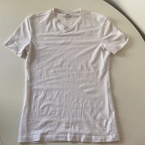 T-shirt - Vit slimmad tröja, i bra skick och har knappt användits. Det är en tight Model och passar till diverse saker!