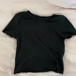 Svart tröja - Säljer denna fina svarta topp från ginatricot som har ribbat vid ärmen och nertill, säljer då den inte kommer till användning💕💕 storlek S 
