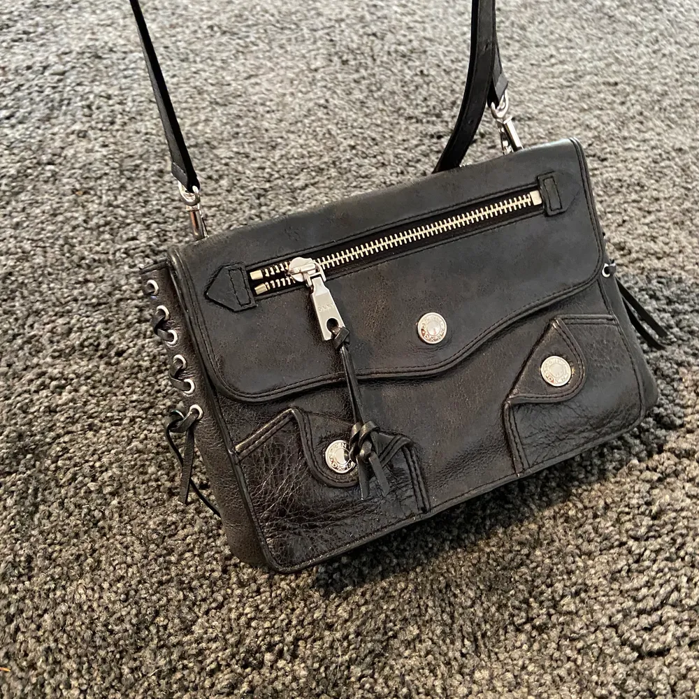 Svart handväska med silvriga detaljer från DKNY, köpt för cirka två år sen men i mycket bra skick men inte använd så mycket då jag inte har väska så ofta. . Väskor.