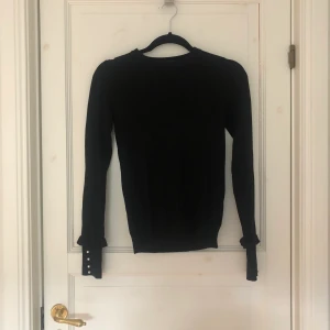 Långärmad tröja med pärlor - Långärmad svart tröja från zara med volang och pärlor vid muddarna. Mjukt och lite tjockare material. Sitter relativt tight och passar till allt. 