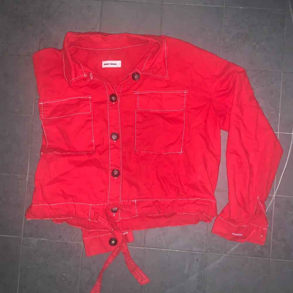 Skitcool röd skjorta som går att Stylea på många olika sätt. Den är från ett märke som heter Tallu Weijls i strl S. Röd röd färg med mörka knappar samt snörning längst ned. Fint skick. Pris exkl frakt. Skjortor.