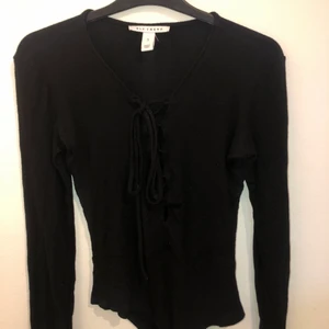 Body  - En långärmad ribbad body från Nelly men snördetaljer fram, storlek S