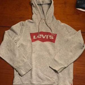 Levis hoodie - Grå levis hoodie i size S. Notera de två små hålen på tröjan!