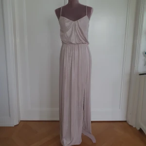  - Shimmrig champagne färgad klänning med slits! Superfint skick, härligt material som lägger sig fint på kroppen. Betalning via swisha frakt 27 kr