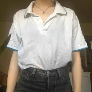  - Vit piké-liknande tröja med blå kant på kragen. En aning genomskinlig och tillräckligt luftig för att kunna ha nu på sommaren. Storlek L men passar perfekt som en oversized tröja på mig (XS/S) Säljer då den aldrig kommer till användning.