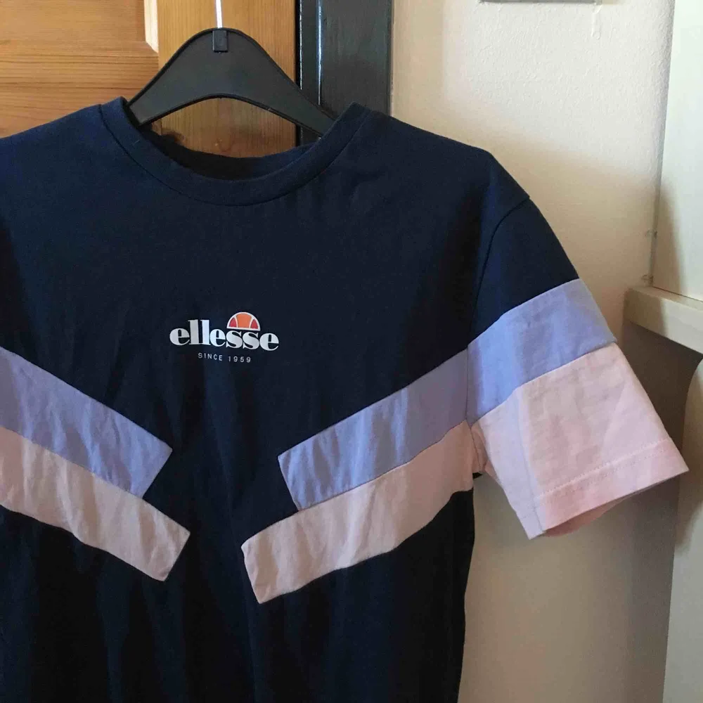 💙 Säljer en marinblå Elesse t-shirt med rosa och lila detaljer. Helt nytt skick, aldrig använd. Köparen står för frakt . T-shirts.