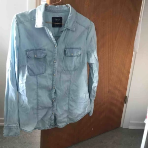  - Ljus jeanskjorta med pärl knappar liten i strl, knappt använd, kan mötas upp i gbg annars står köparen för frakt