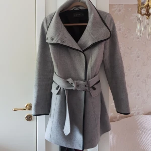  - Feminin och snygg kappa från Esprit. Fungerar till både vinter, höst och vår. Måttligt använd. Hål i ena fickan. Nyligen kemtvättad.