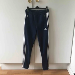  - Mörkblå adidasbyxor. Säljer pga att de är för små. Kan skicka men då tillkommer fraktkostnad! Storlek 150 (ungefär som XS)
