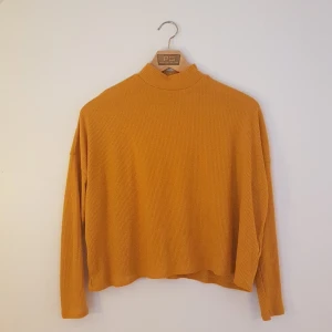 Senapsgul croppad polotröja, stl S - Härligt senapsgul croppad tröja med hög hals. Vid passform så faller snyggt. 🌻 Från H&M Divided. Stl S. Polyester. Frakt tillkommer.