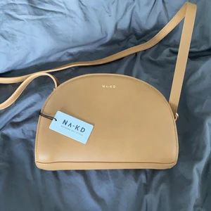 NA-KD handväska  - Säljer min helt oanvända handväska från NA-KD då jag inte gillar färgen. Rätt rymlig med ett innerfack. Vet inte alls vad som är ett rimligt pris för denna då jag inte minns inköpspriset så kom gärna med ett bud. Skicka meddelande för fler bilder 🌸