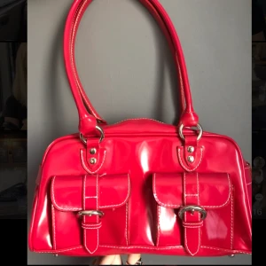 Intressekoll! Röd glansig handväska! - En röd glansig väska från humana,är i helt nyskick Inga fel på den,köpt för dyrt,buda 10kr över varandra om igen budar på 24h så får den som budade sist väskan!!mörkare irl