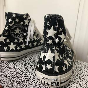 Svarta Converse All Star sneakers dekorerade med stjärnor. 