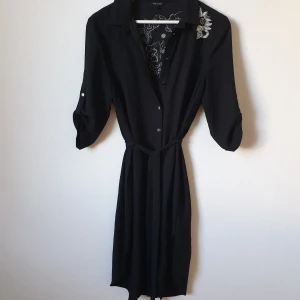 Black shirt dress with details - Black shirt dress wirh embroidery on the back . Size 12 - 38. 