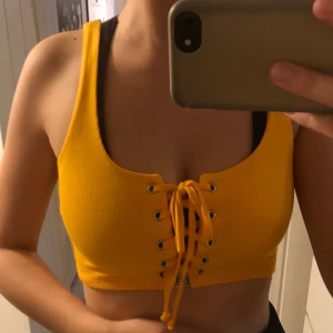 gult linne med snörning - Gul/oranget linne med snörning från bikbok. Aldrig använd. Köparen står för frakten.