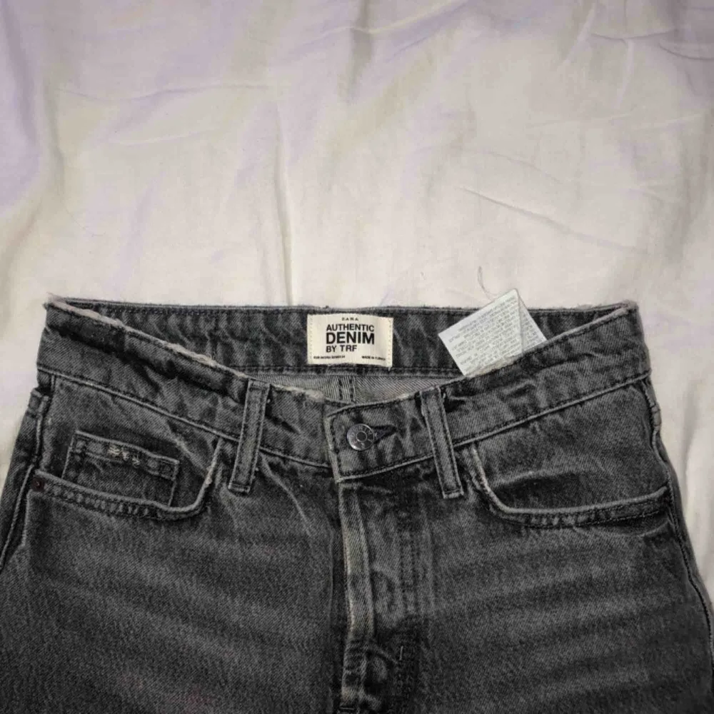 High waisted gråa jeans från ZARA med slitningar på änden i storlek 34. Jeans & Byxor.