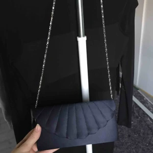  - Marinblå axelärmväska som är använd vid ett tillfälle på en konfirmation. Superfin och superskönt material, funkar även för bal eller liknande😊 Fraktar om du betalar frakten, fråga ifall du har frågor!😊💕