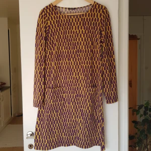  - Lila-gul mönstrad klänning från Marimekko. Fickor på framsidan. Kan mötas i Uppsala, eller så står köparen för frakt.