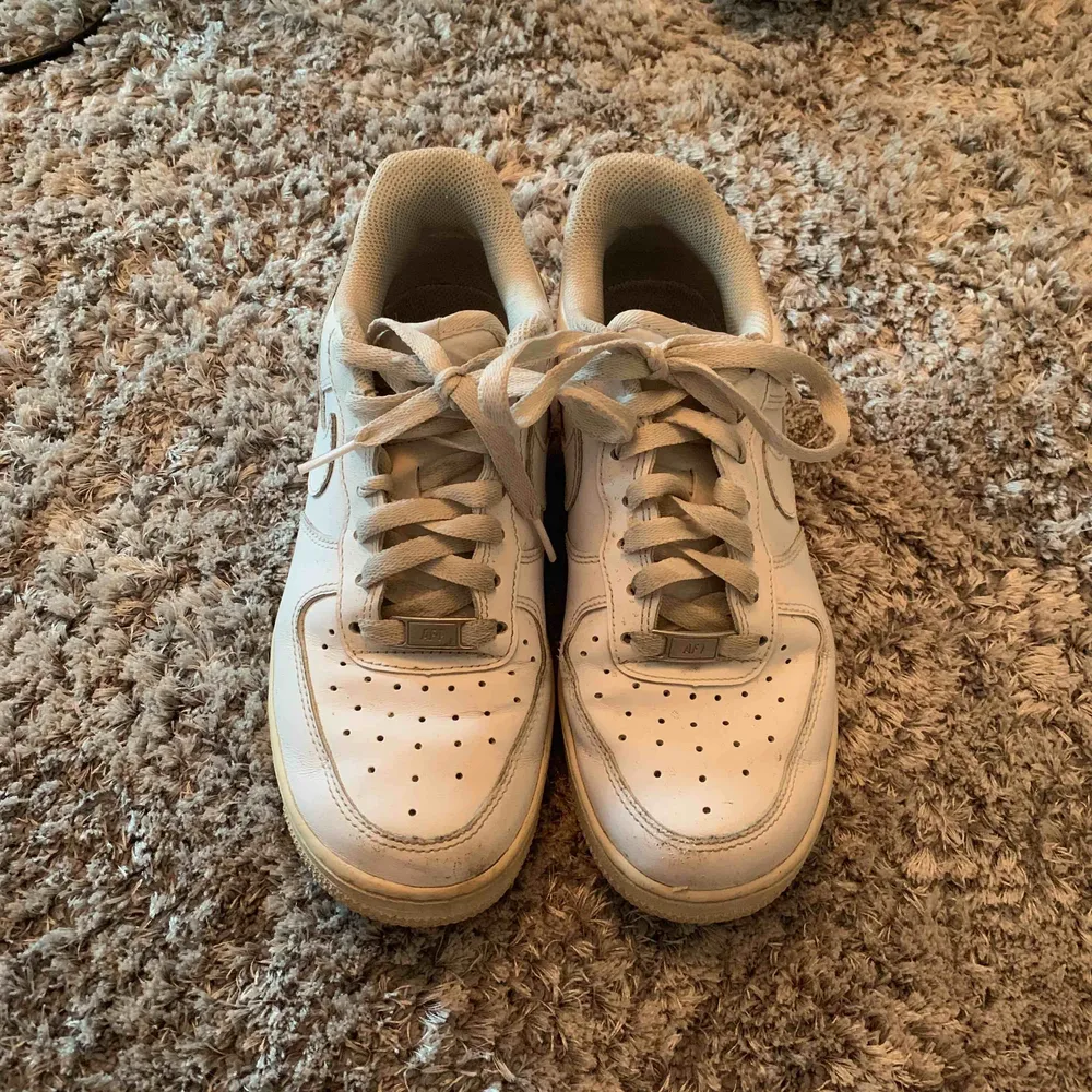 Nike air force 1. Inga stora slitningar som påverkar skons kvalité. Den största slitningen är uppe vid den högra skon, se bild 3. . Skor.