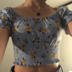 Blommig topp strl xs - Toppen köpt på Monki. Jag använder den inte tillräckligt så den är i väldigt bra skick. Den är kroppad och man kan använda den som en t-shirt eller off shoulder. 