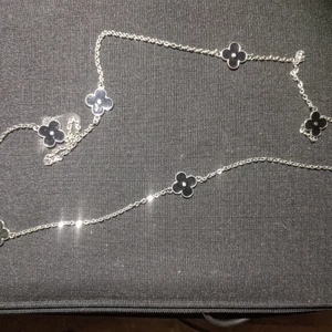Halsband - Längre halsband med svarta fasta  blommor längs länken. Nickelfritt. Alla smycken ta 3 betala för 2, billigaste på köpet