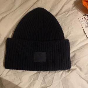 Acne studios mössa, navy blue - En mössa från acne studios i nästan helt nytt skick. Endast använd ett fåtal gånger. Nypris: 1100kr. Säljer för 450kr då den nästan är helt ny. Mörkblå.