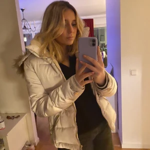 Vinterjacka - Superskön och fin vinterjacka. Den är i crämvit och har mysigt fluff inuti, jättestor o fin luva. Den är i strl M. Pris går att diskutera