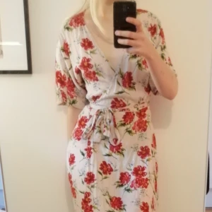 Blommig maxiklänning  - Blommig maxiklänning knyts i midjan, var gulaktig från början men är lite urtvättad i färgen. Behöver strykas men väldigt fin och bekväm på sommaren. Köpt på Mango. Storlek small men passar nog även medium. 