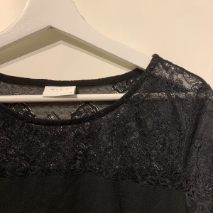 Svart T-shirt med spets - VILA - 36 - Svart tröja från VILA med spets upptill. Materialet är lite blus aktigt! Storlek:36 (S) Pris: 90kr + frakt 