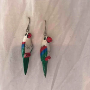  - Örhängen med papegojor. Något slitna på näbben men övrigt riktigt fina. Gjorda i trä så väger knappt något! Frakt ingår ☀️