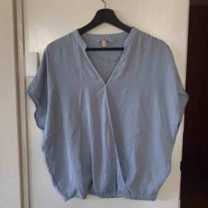  - Blus i fin ljusblå, passar 34-38. Kan fraktas!