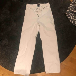  - Vita vida/raka jeans med flera knappar istället för gylfen! Storlek 34