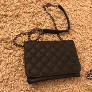  - Oanvänd väska med svart kedja 