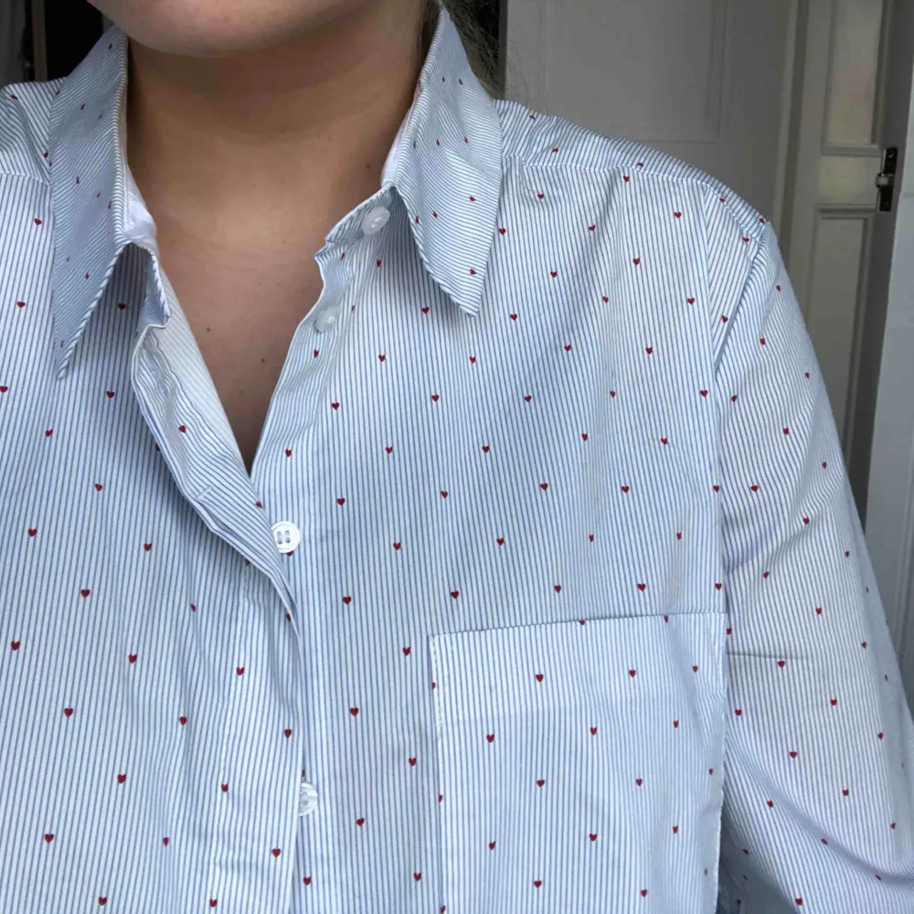 Vitblå randig skjorta med små röda hjärtan, lite oversized på mig som brukar ha S. Supersnygg till allt, särskilt på våren/sommaren!. Skjortor.